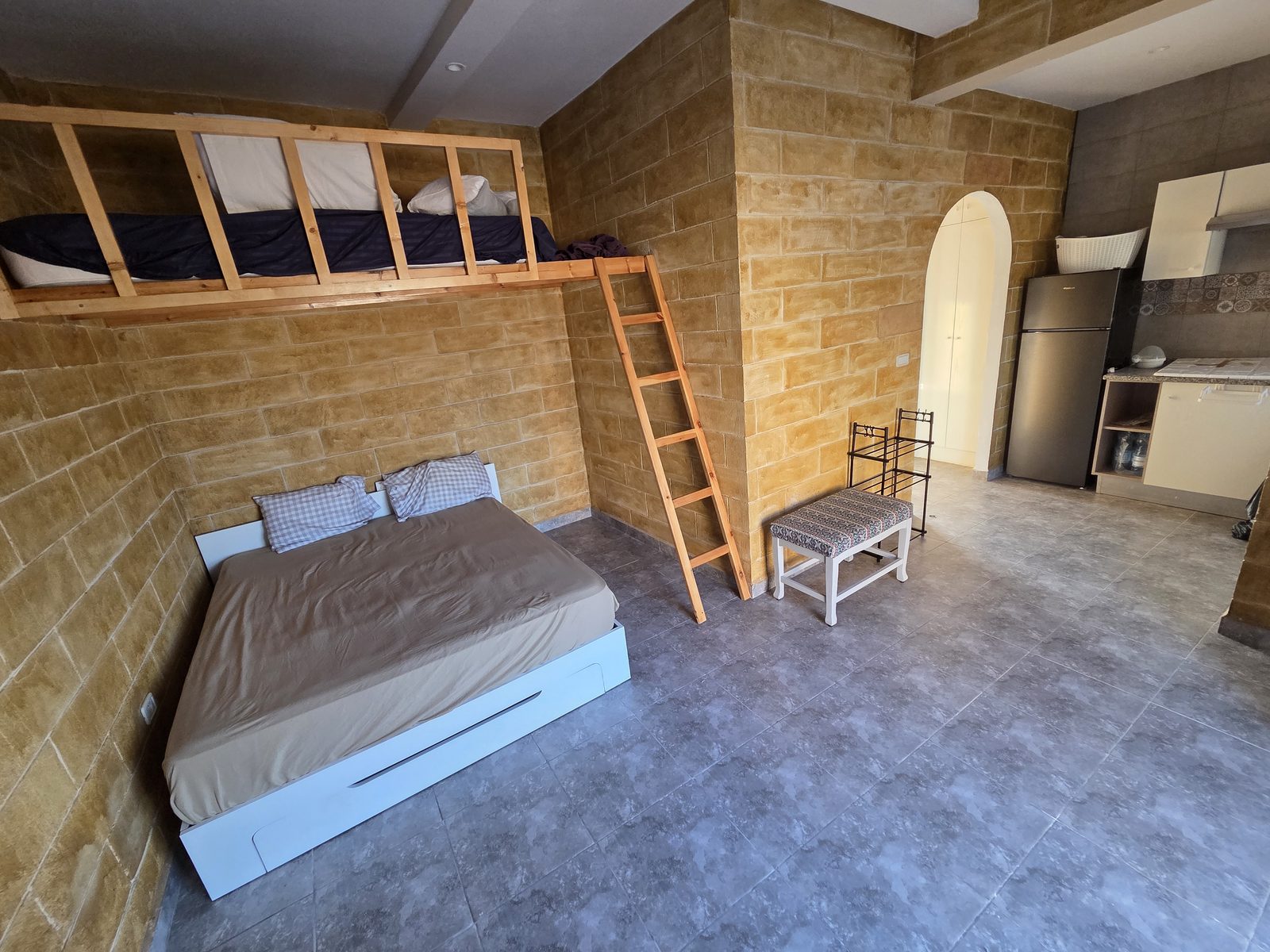 Room 1 — double bed, mezzanine and kitchen corner
